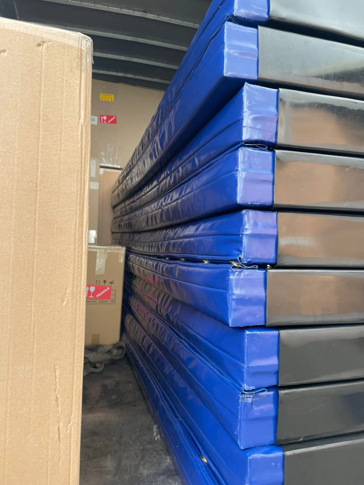Stack of mattresses with blue PVC corner protectors built for a fleet of trucks
