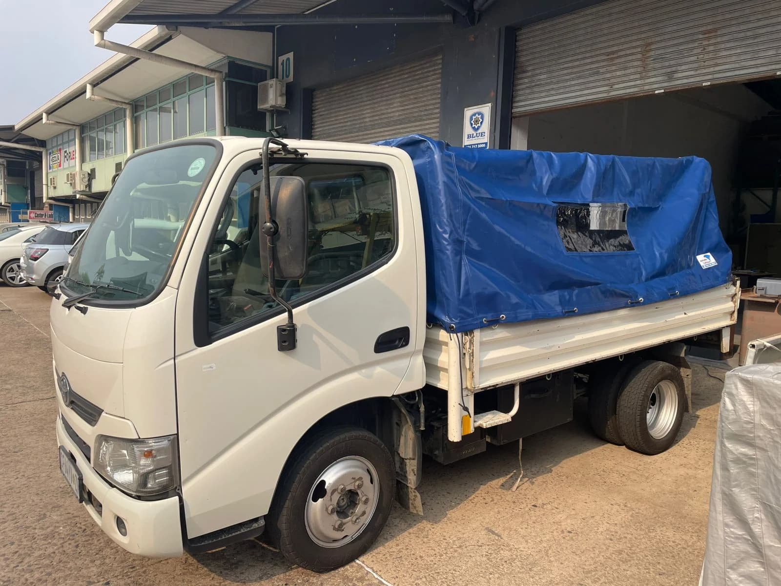 Toyota Dyna truck cargo bay covered with a blue Minurphy PVC load tarp