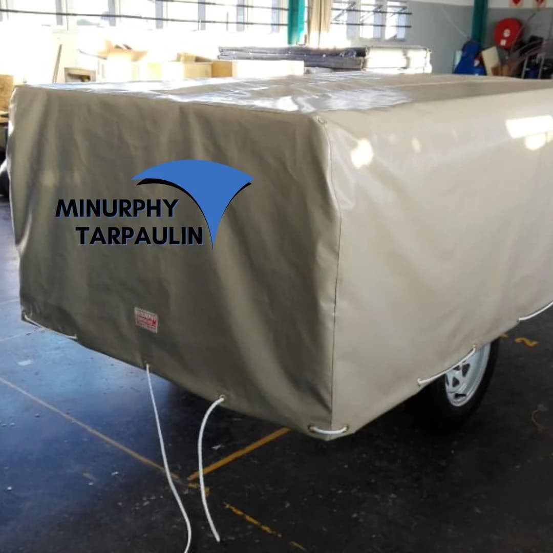 Beige PVC trailer cover with reinforced corners on the Minurphy factory floor